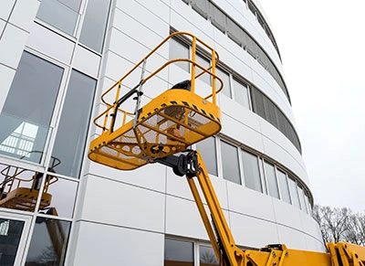 Cesto de plataforma elevatória em fachada predial — operação segura Big Lift Rental