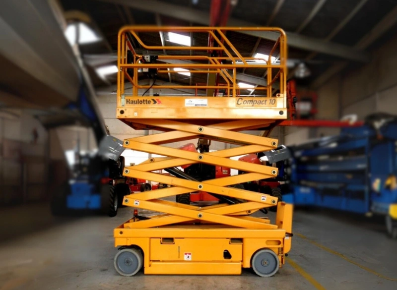 Plataforma tesoura Haulotte Compact 10 elevada em galpão